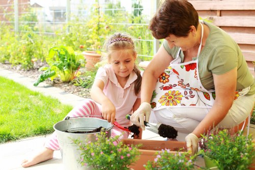 Team of gardeners with tools at front of a property representing insured gardening services