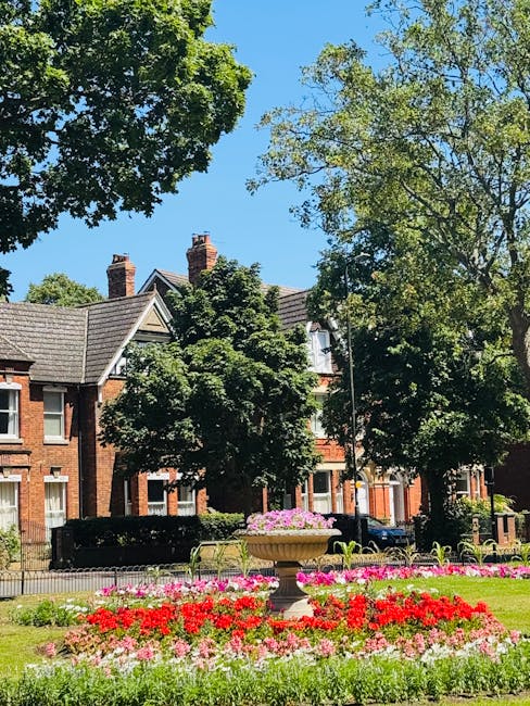 A close-up view of a small front garden in a residential area showcasing two green painted wooden front doors with house numbers 31 and 33, set within a brick façade. The door to number 31 features a